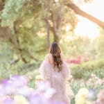 Xio Ponce Bay Area Family Photographer photo of pregnat mom in a Irish garden with a pink dress walking away.