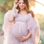 Xio Ponce Bay Area Family Photographer photo of pregnat mom in a Irish garden with a pink dress holding her belly.